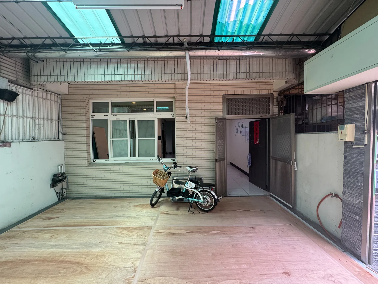施工前：車庫只停一台電動腳踏車，大門靠右邊，旁邊沒有鞋櫃