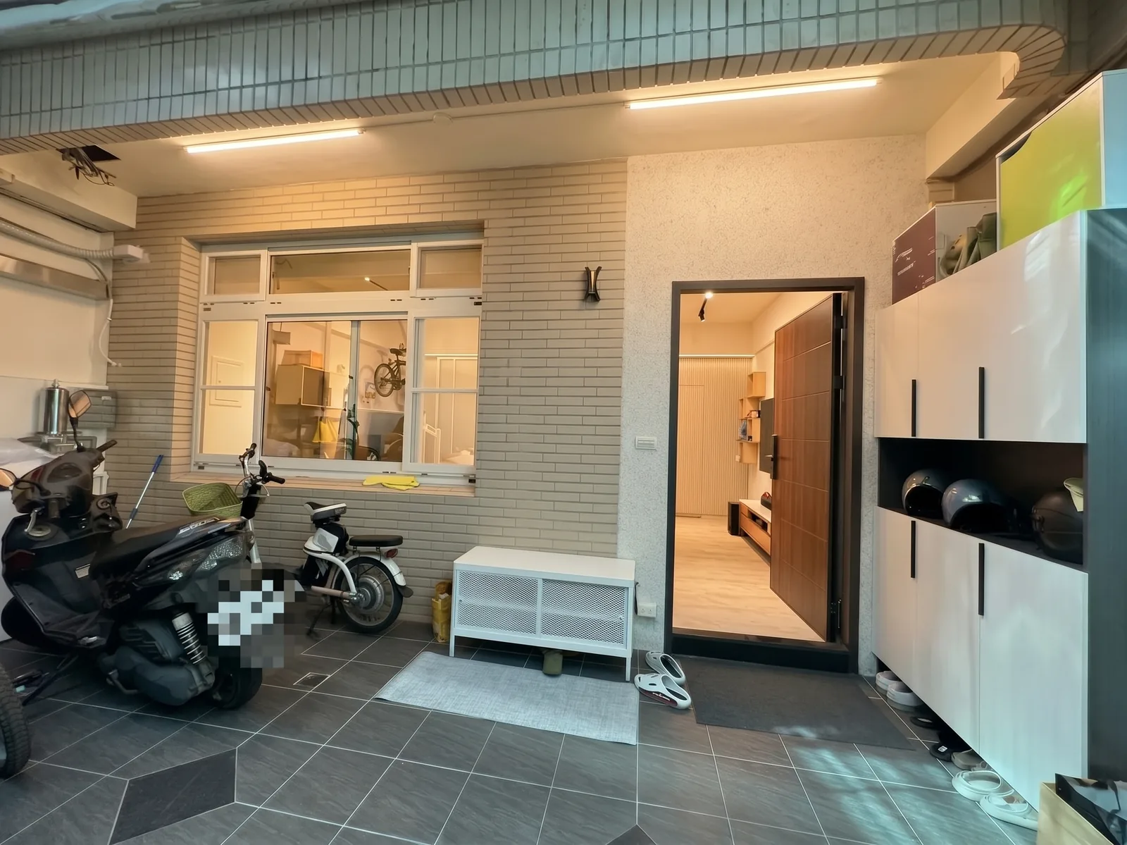 完工實拍：機車停進車庫，大門旁的鞋櫃收進鞋子與安全帽，門口擺著穿鞋凳
